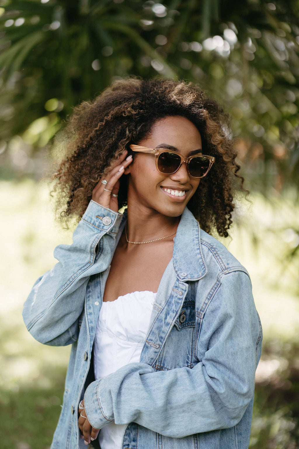soek lila grace champagne cat-eye sunglasses worn by smiling woman outdoors