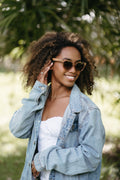 soek lila grace champagne cat-eye sunglasses worn by smiling woman outdoors