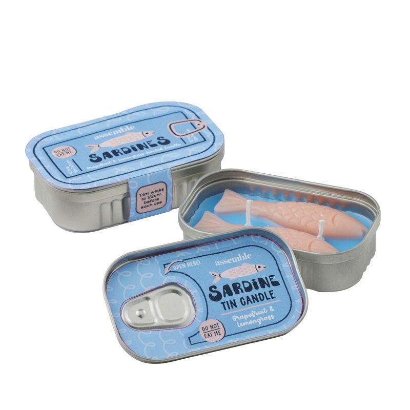 assemble sardine tin candle open showing fish-shaped wax candle with blue denim label